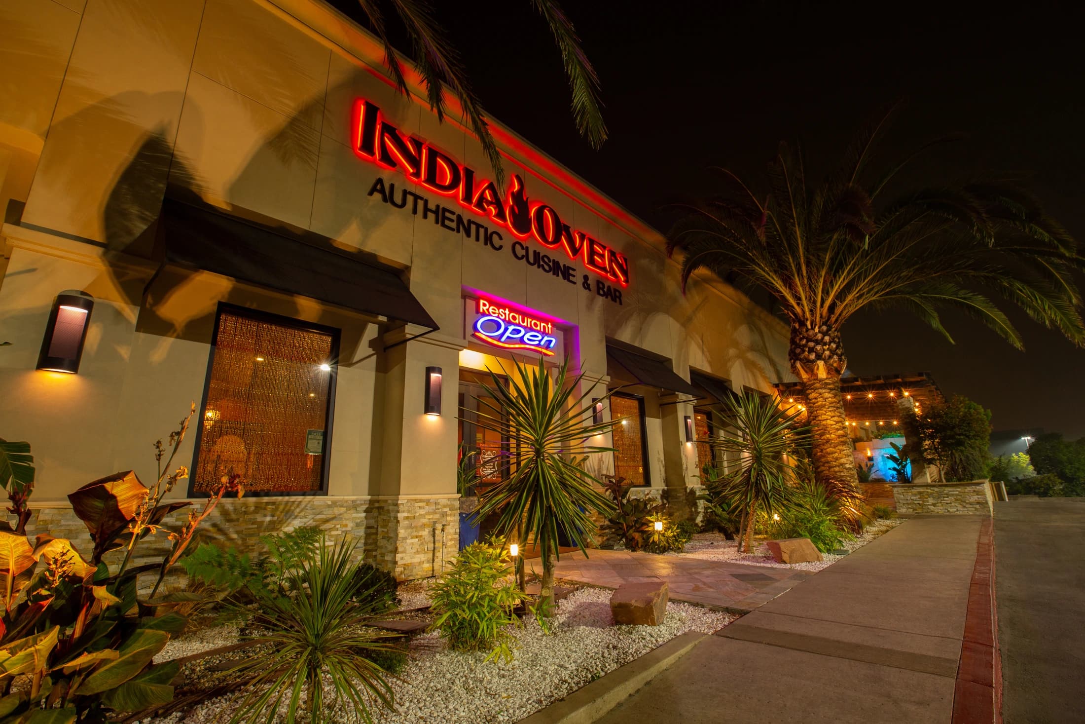 The illuminated entrance to India Oven